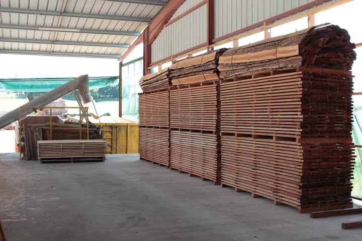 Stock de grumes et de planches sciées dans l'atelier de la Scierie GRAS